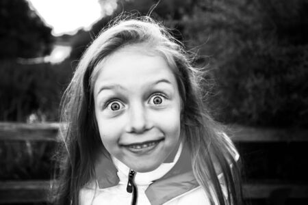 portrait of a surprised little girl on the background of the Park. black and white photoの写真素材