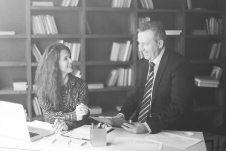 Businessman and assistant discussing a working paper