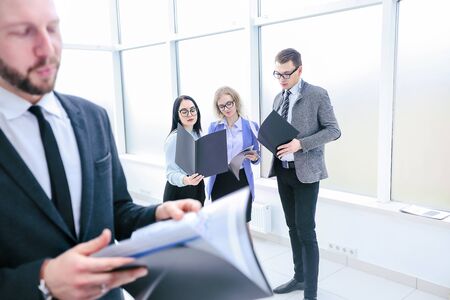 Businessman and his colleagues studying business documents standing in the office.の写真素材