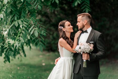 portrait of a happy couple of newlyweds on the background of the summer Parkの写真素材