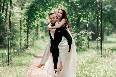 cheerful bride and groom standing under the wedding archの写真素材