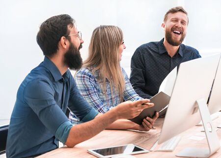 cheerful employees discussing something at a meeting in the office
