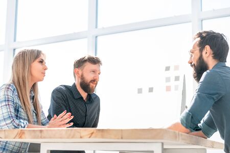 Employer talks to employees at a meeting in the office.の写真素材