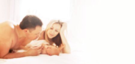 happy parents looking at their newborn daughter. blurred image for the advertising text.