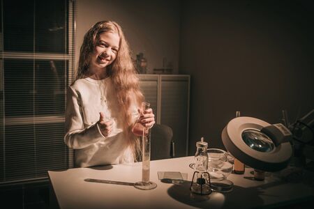 cheerful girl schoolgirl standing near the table in the chemistの写真素材