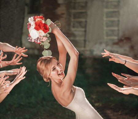 beautiful bride throws wedding bouquet to her friendsの写真素材