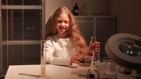 teenage girl sitting at a table in the lab.の写真素材