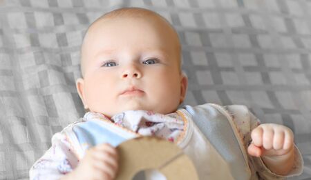 close up.portrait of a pretty little baby lying on a plaid blankの写真素材