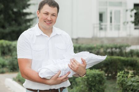 happy father with his newborn baby standing near the maternity hospital