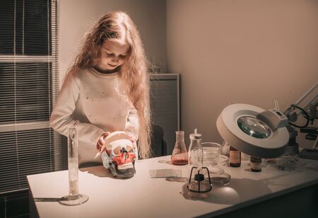 girl schoolgirl studying the structure of the human skull