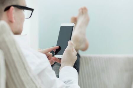 Business man reading online news on his smartphoneの写真素材
