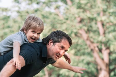 dad plays with his little son on a walk in the Park .の写真素材