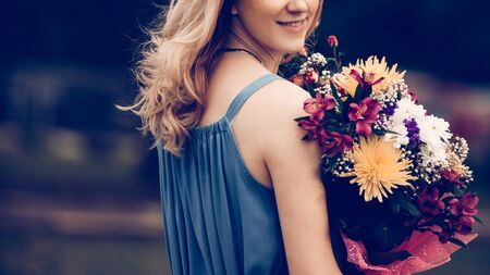 close up.smiling young woman with a bouquet of flowersの写真素材