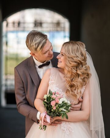 bride and groom standing under the arch of the city building.の写真素材