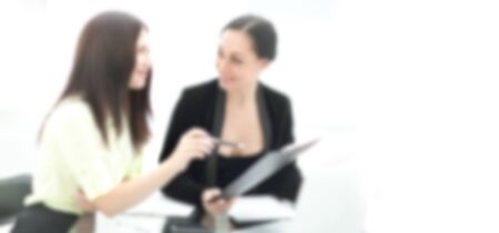 blurred background with copy space. two business women discussing financial documentsの写真素材