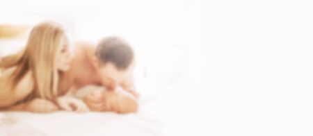 happy mom, father and their newborn daughter. blurred background with copy space. concept of parenthoodの写真素材