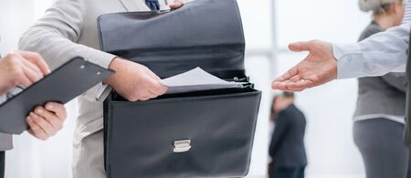close up. entrepreneur handing documents to the Bank employee.の写真素材