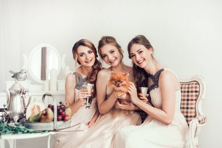 happy girls and the bride sitting in the boudoirの写真素材