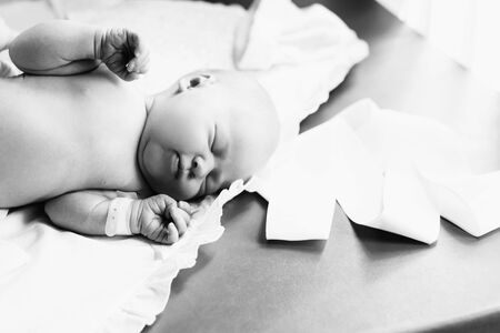 pretty newborn baby with tag on hand