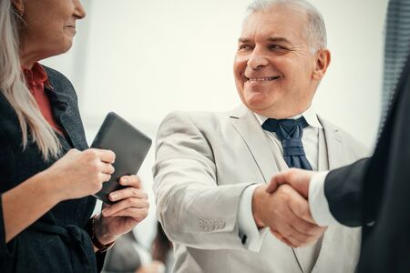 close up. confident business people shaking hands with each other.