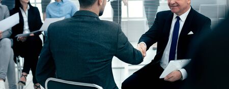 business colleagues shake hands sitting in the conference room