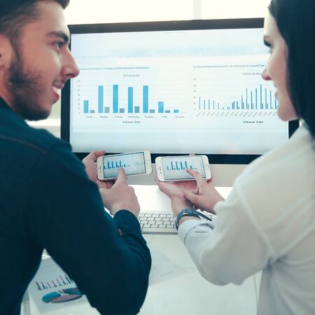 rear view.business couple discussing financial charts, sitting