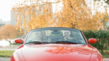 happy bride and groom sitting in a luxury car.の写真素材