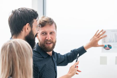 business partners discuss financial schedules standing in the officeの写真素材