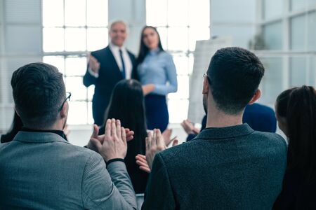 rear view. company employees applauding at a work meetingの写真素材