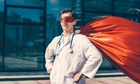 serious doctor in a superhero Cape standing on a city streetの写真素材