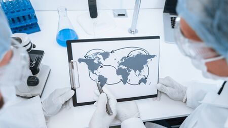 close up. map of the spread of coronavirus in the hands of an epidemiologist. Elements of this image furnished by NASAの写真素材