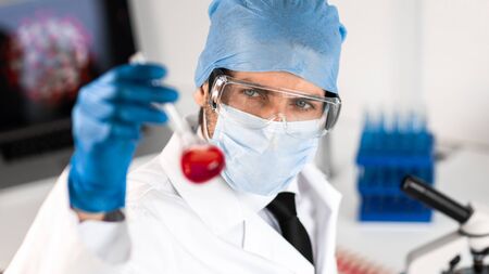Scientist carefully looking at the test tubeの写真素材