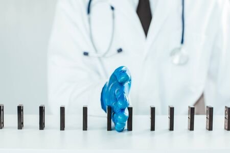 A doctor using dominoes to show a safe distanceの写真素材