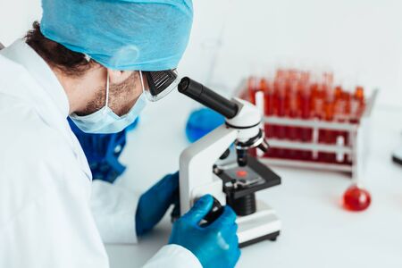 Scientist looking at a control sample through a microscope.