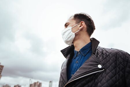 A man in a protective mask against the modern cityの写真素材