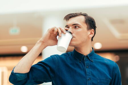 A attractive young man with a coffee to take awayの写真素材
