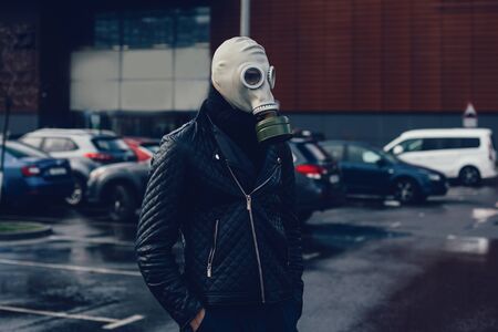 A man in a gas mask standing in a city Parking lotの写真素材