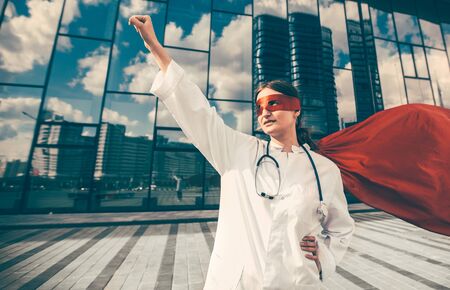 A female doctor in a superhero Cape is ready to helpの写真素材