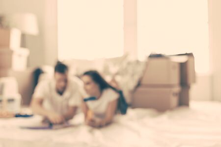 background image of a young couple lying on the floor in an empty new apartment.の写真素材