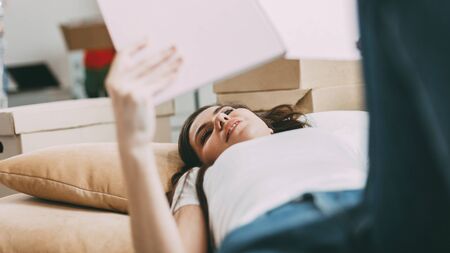 young woman with a project of her apartment lying on the floor.の写真素材