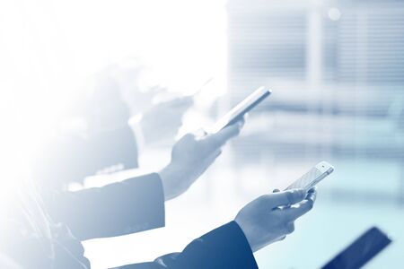 close up . young business people with smartphones standing in line. people and technology