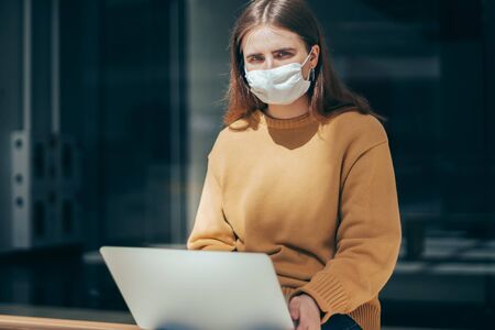 young woman works on a laptop during a pandemicの写真素材
