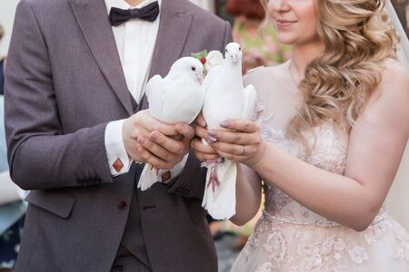 close up. white doves in the hands of the newlyweds. holidays and events.の写真素材