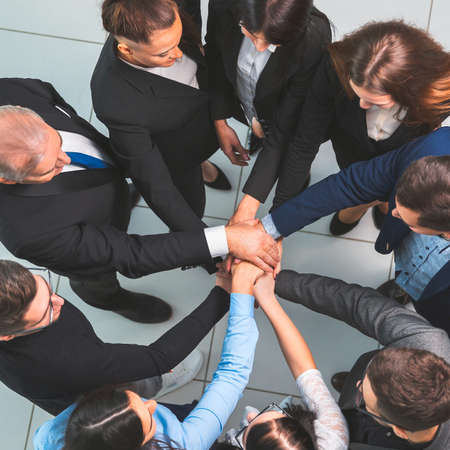 top view. boss and business team making a stack of hands