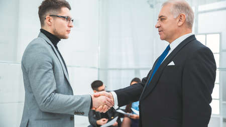 side view. serious business partners shaking handsの写真素材