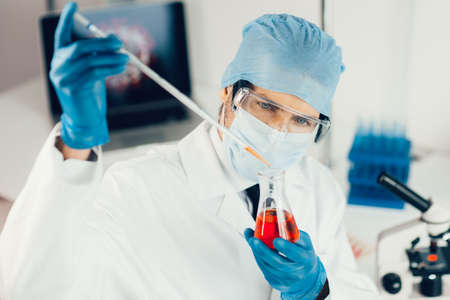 close up. the scientist carefully looking at the test tube .