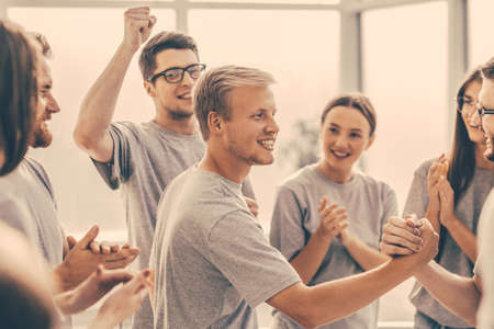 group of cheerful students applauding rivals during the training