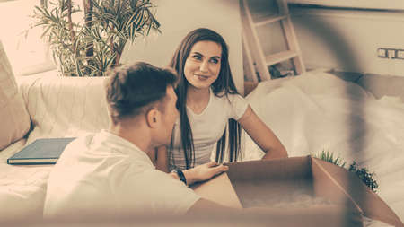 happy couple opening boxes in a new apartment .