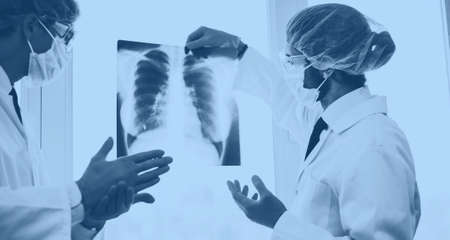 close up. scientists in protective masks looking at an x-ray of the lungs .