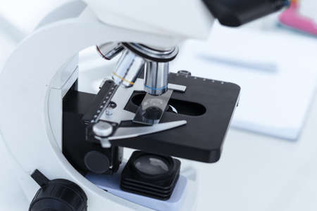 image of a microscope with a sample on a table in the laboratory.
